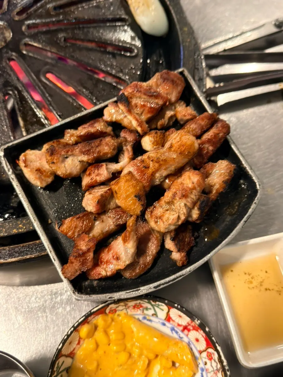 A piece of kkodeulsal served with shredded scallions