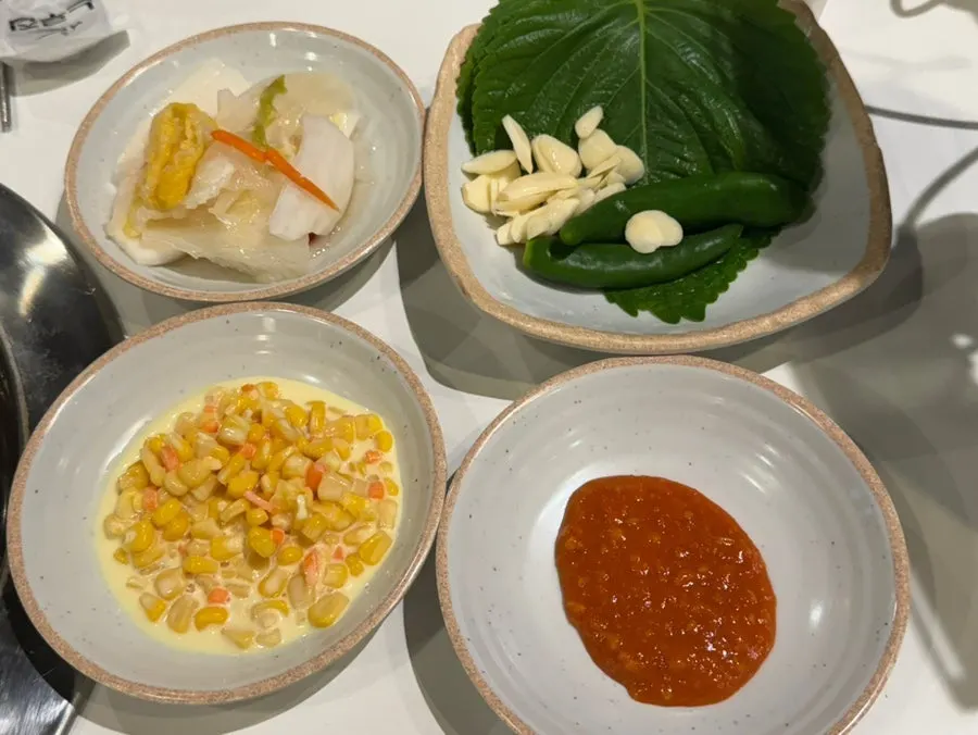 Basic side dishes of corn, kimchi, and wrap vegetables