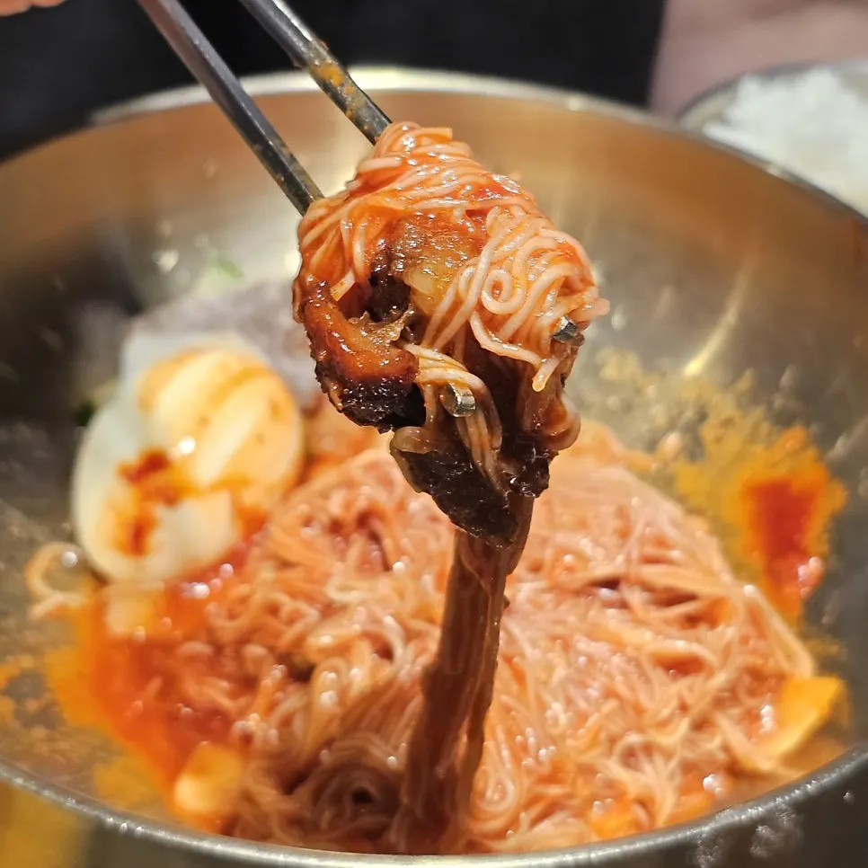 A piece of marinated rib placed on top of naengmyeon