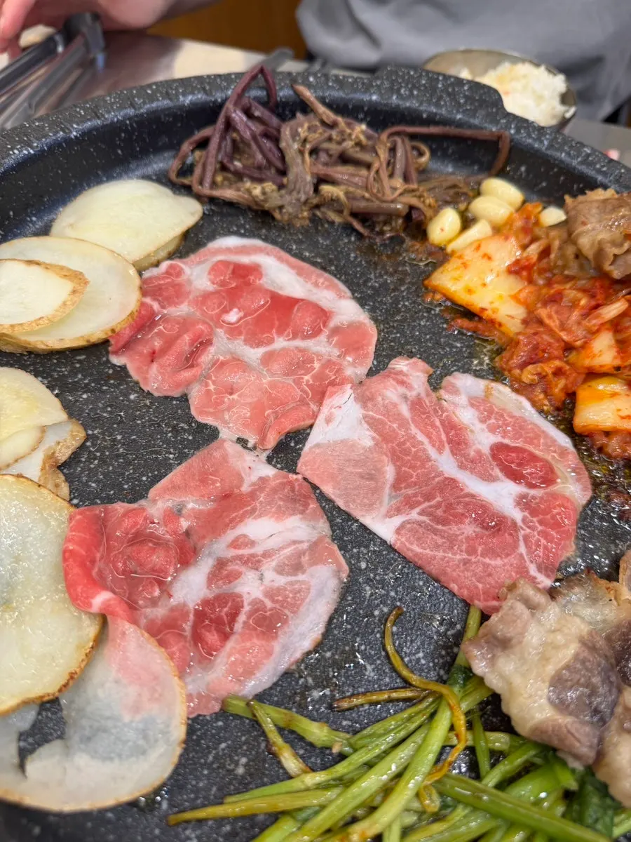 Frozen pork neck being grilled