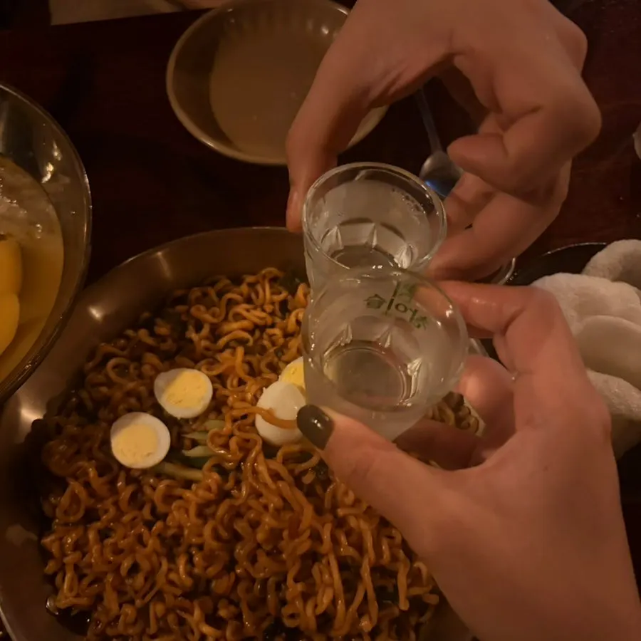 Table spread of canned peaches and jjapaguri, a sweet-and-salty combo