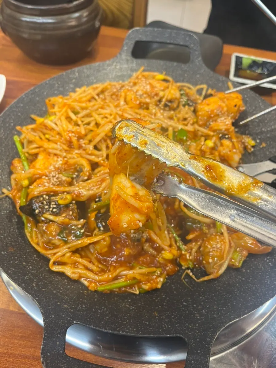 A plump piece of monkfish held with chopsticks