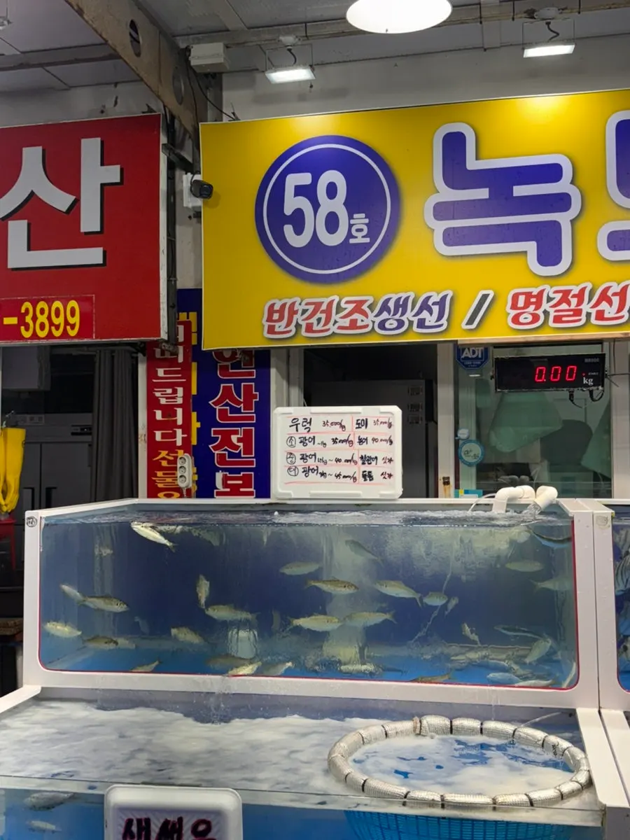 Sign showing per-kilogram prices for live fish sashimi