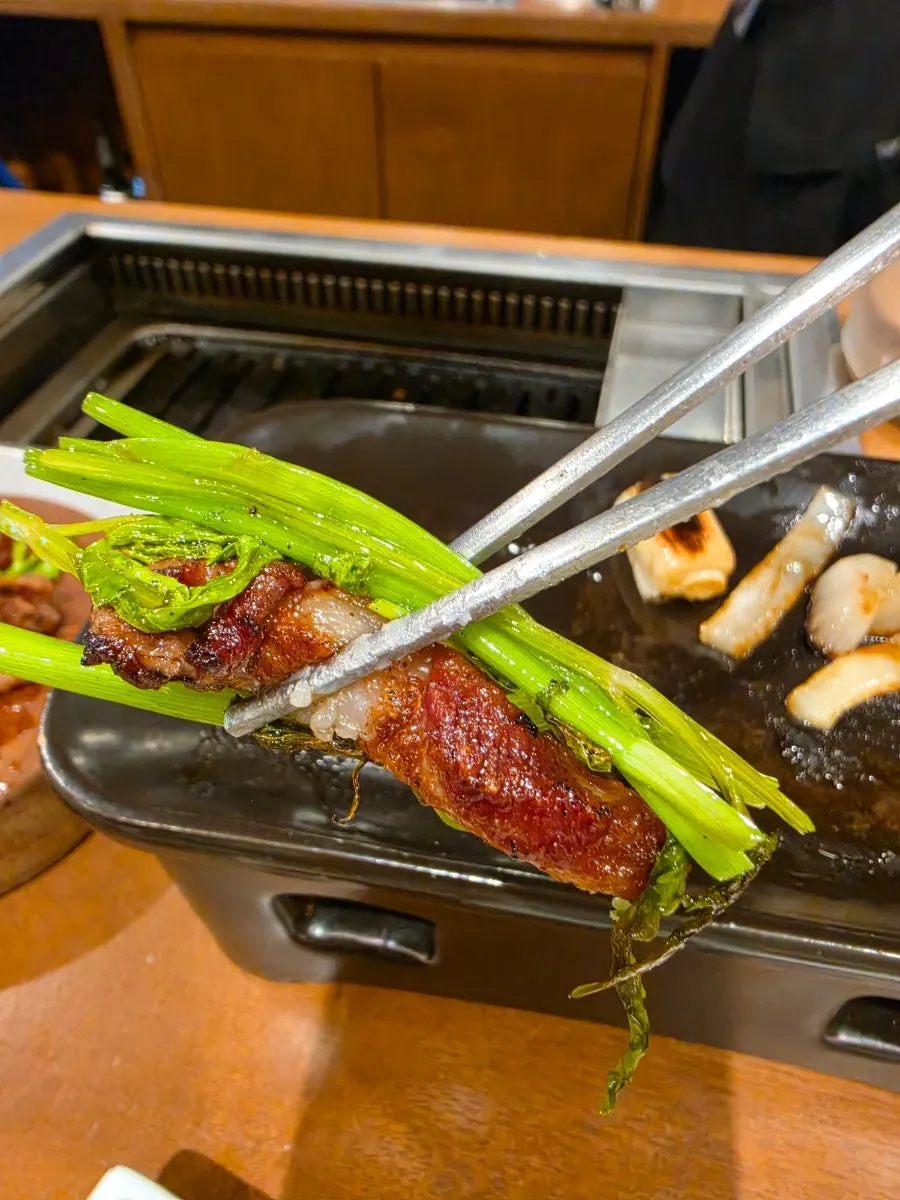 A piece of intercostal meat topped with minari
