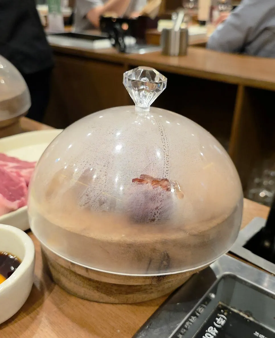 Grill covered with a dome for the final smoking step