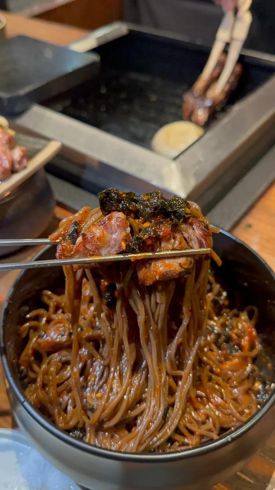 메밀막국수에 구운 고기 한 점을 얹은 모습