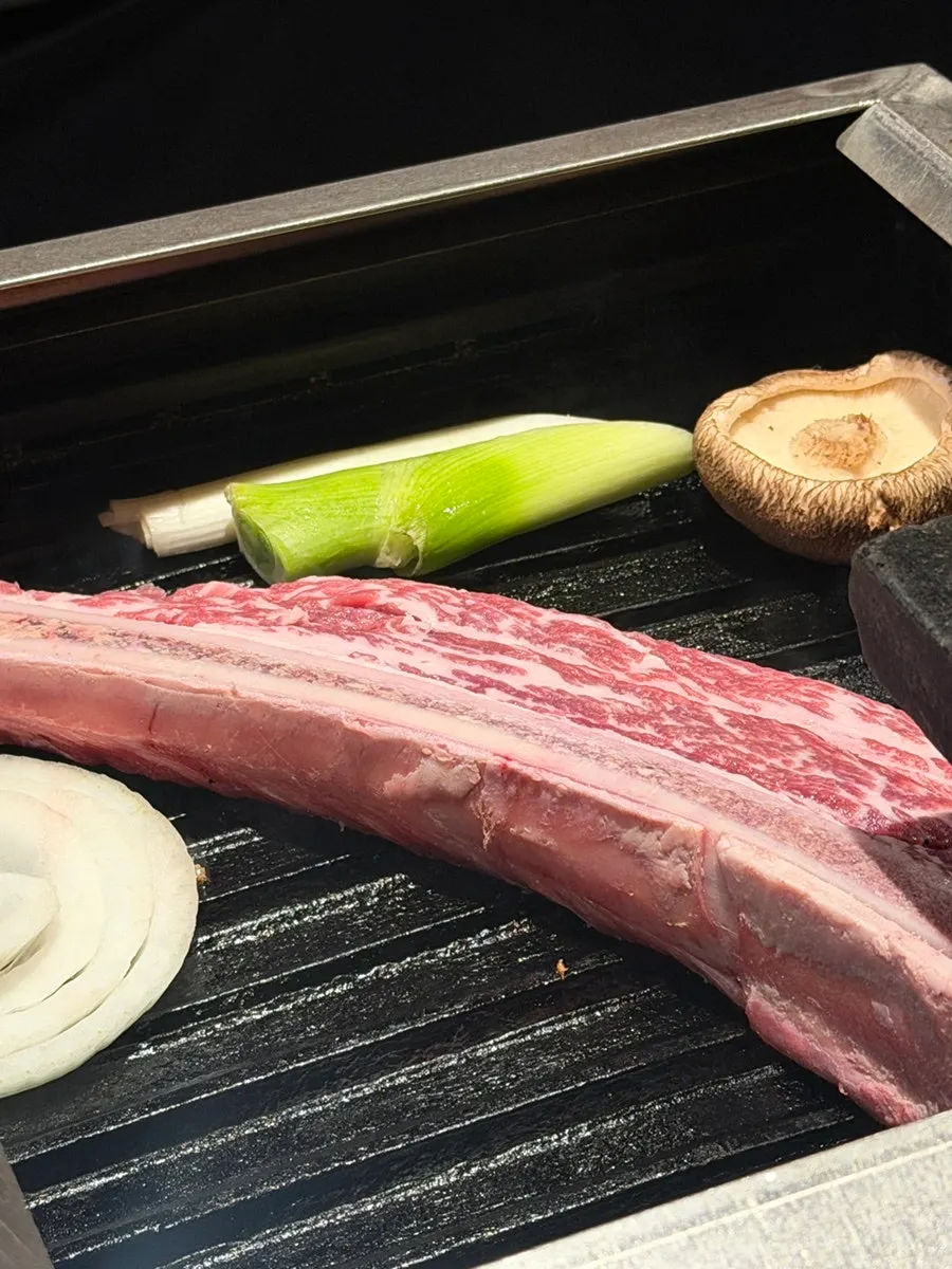 Dry-aged short rib being grilled