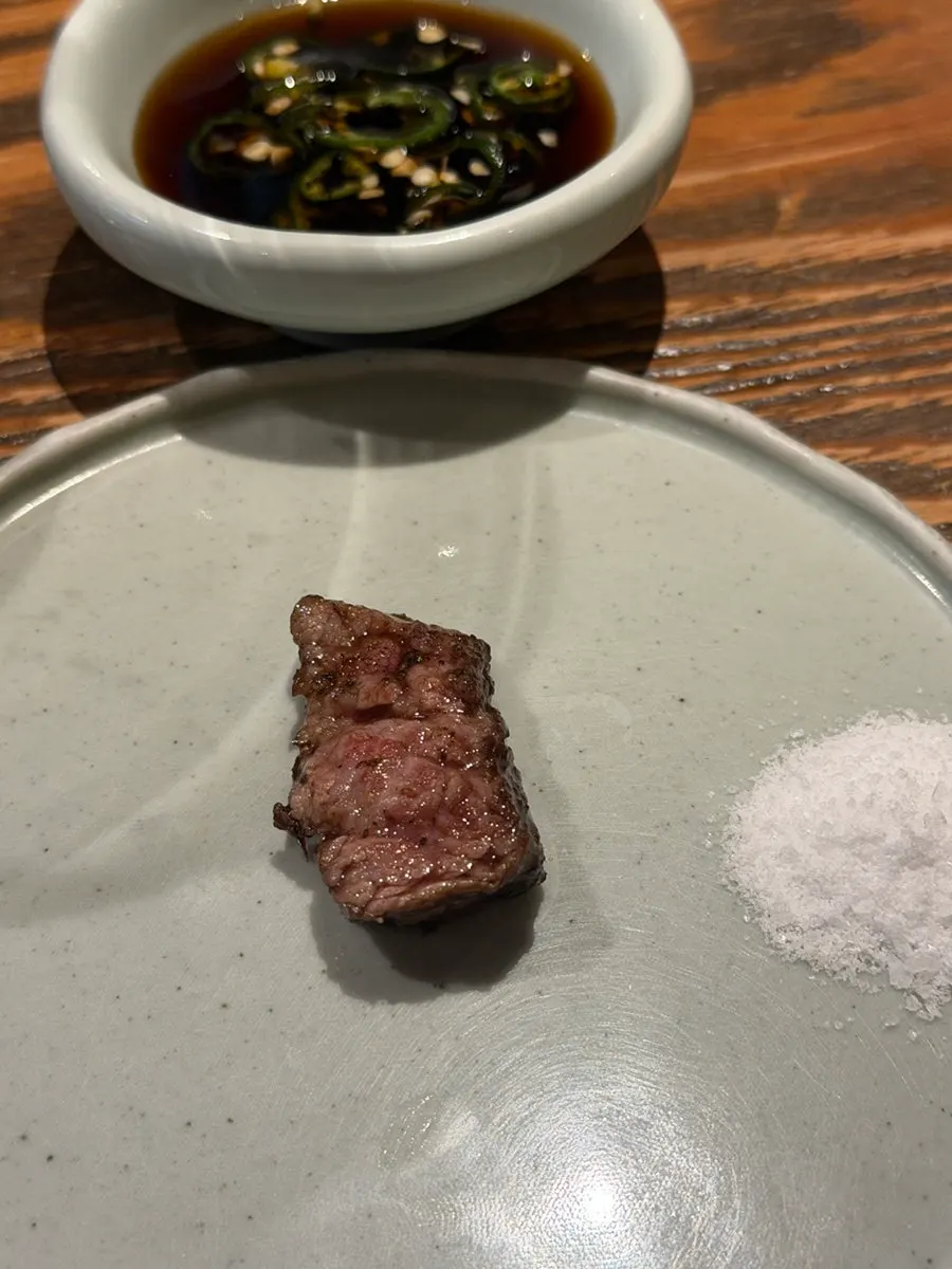 Dry-aged short rib cooking on the grill