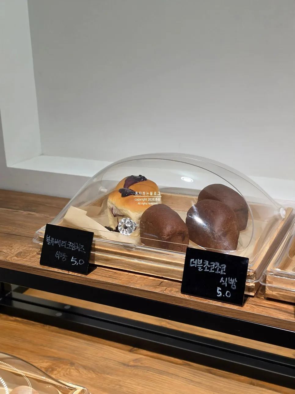 카운터 옆 베이커리 진열대의 빵과 디저트
