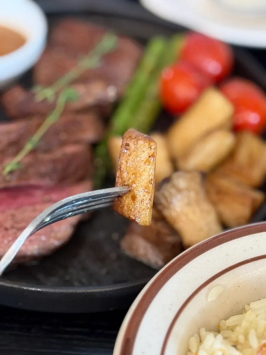 A piece of steak topped with butter galbi sauce and whole-grain mustard