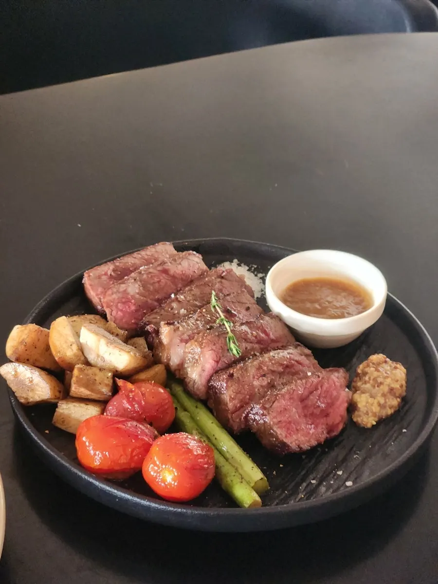 Table setting with steak and pasta ordered for two
