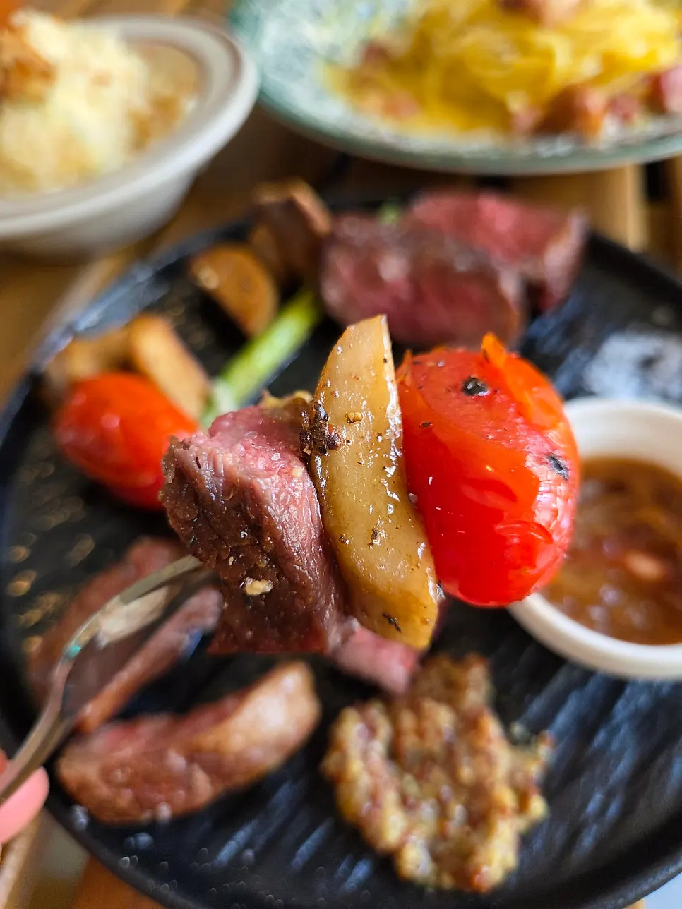 A bite of steak topped with whole grain mustard