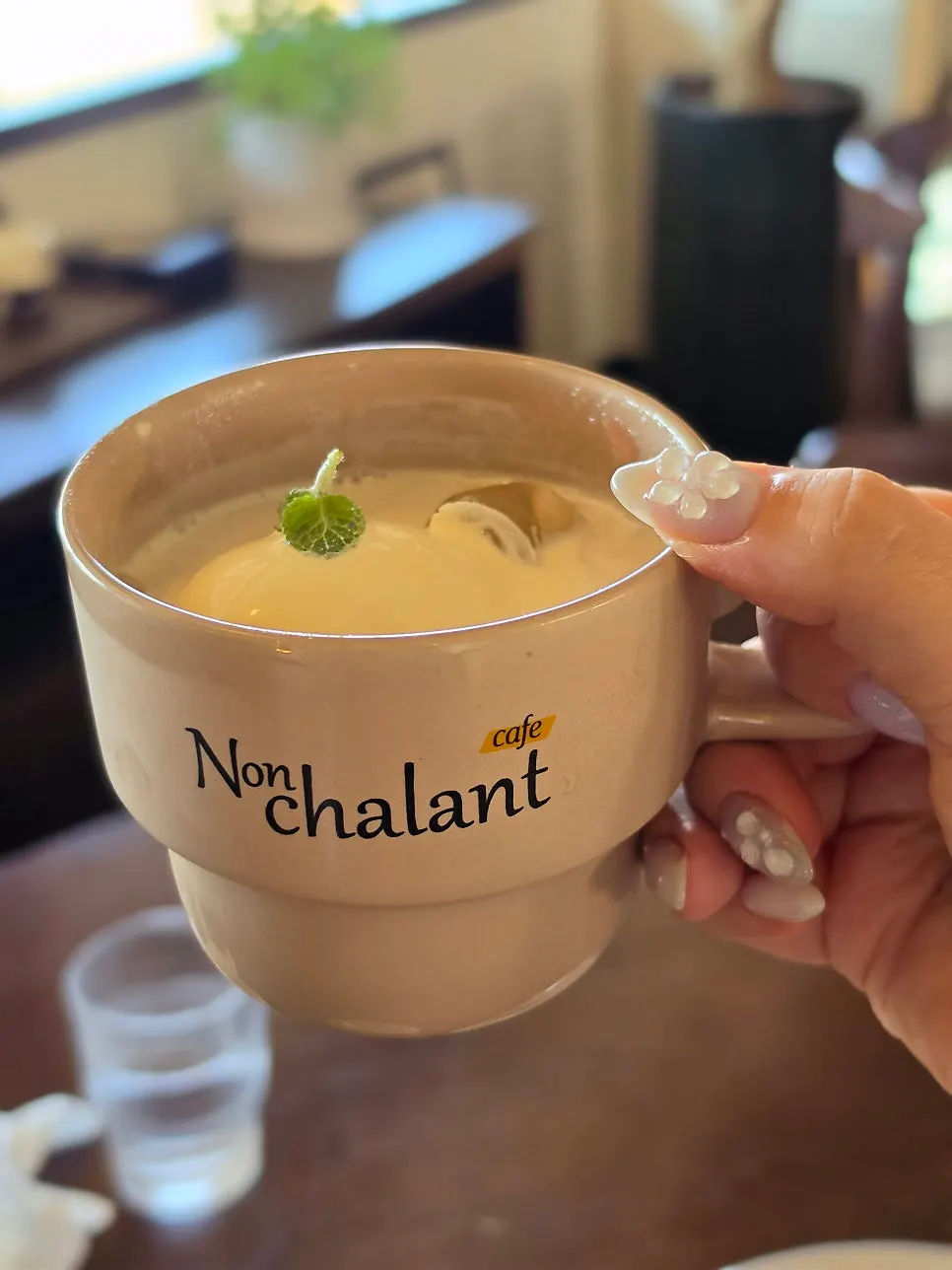 Apricot milk tea and coffee placed by the window