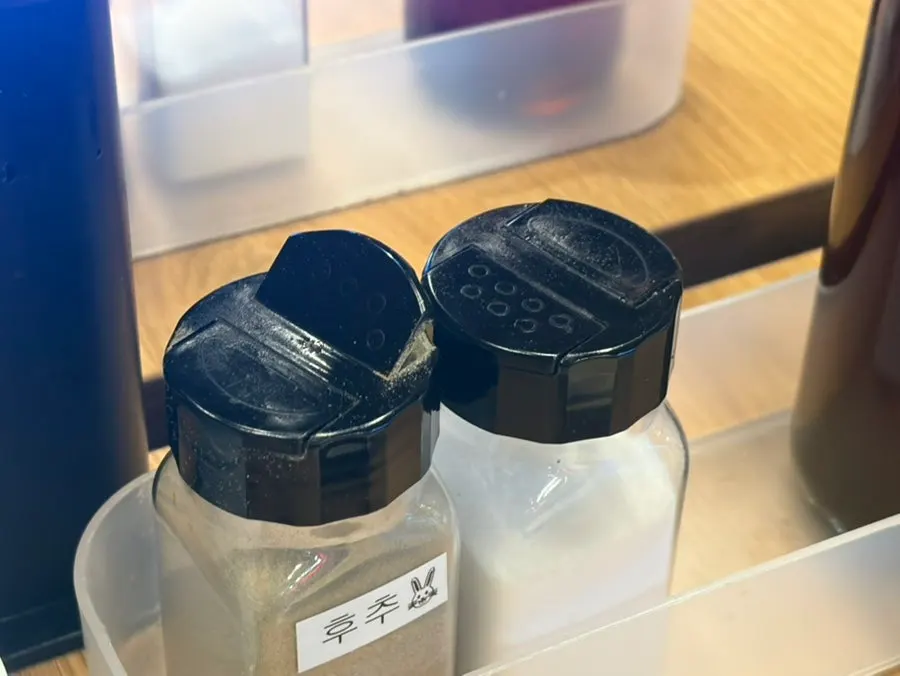 Sesame seeds, pepper, and sesame oil set on the table
