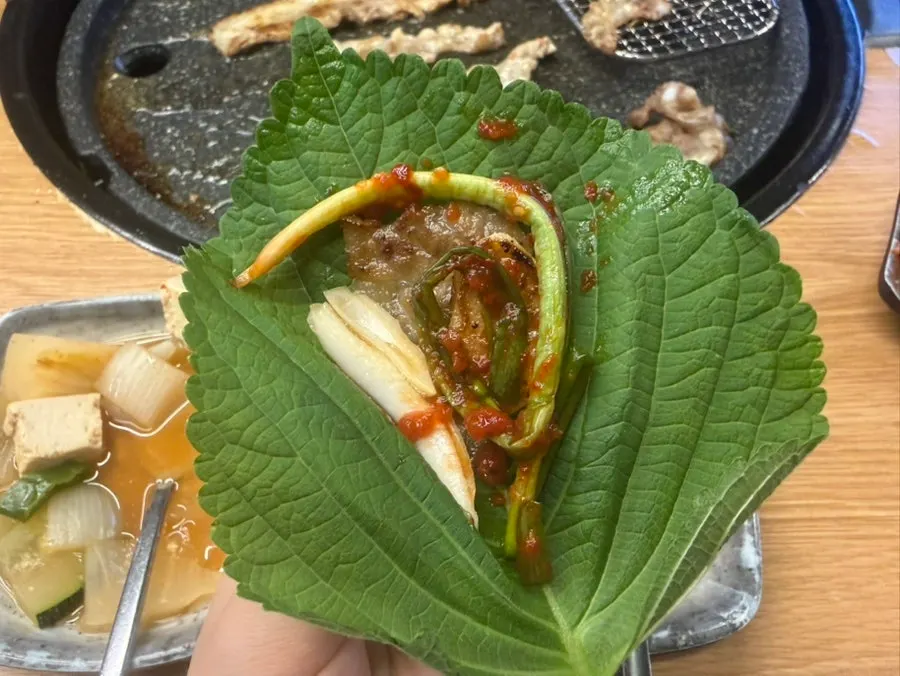 A wrap vegetable topped with meat and garlic