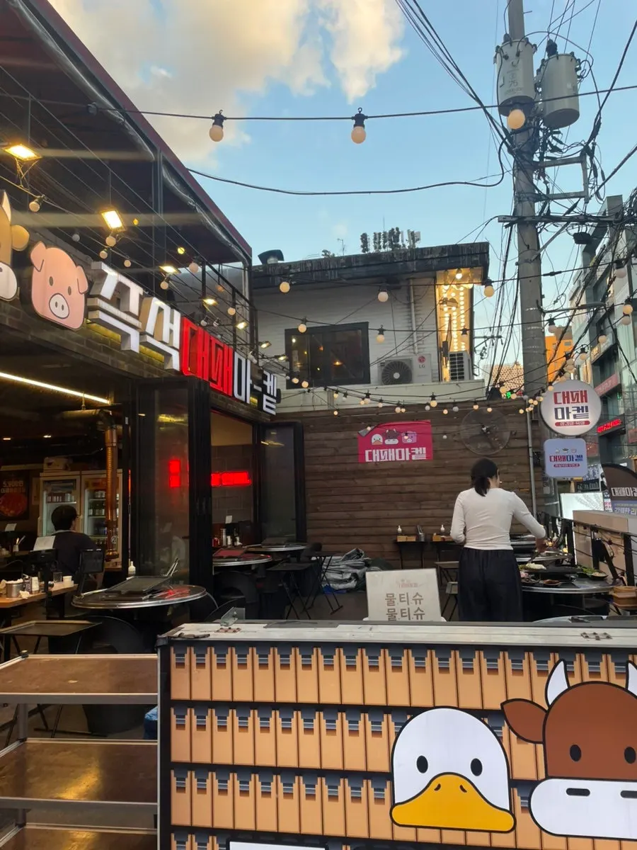 Storefront with the first-floor sign and outdoor tables