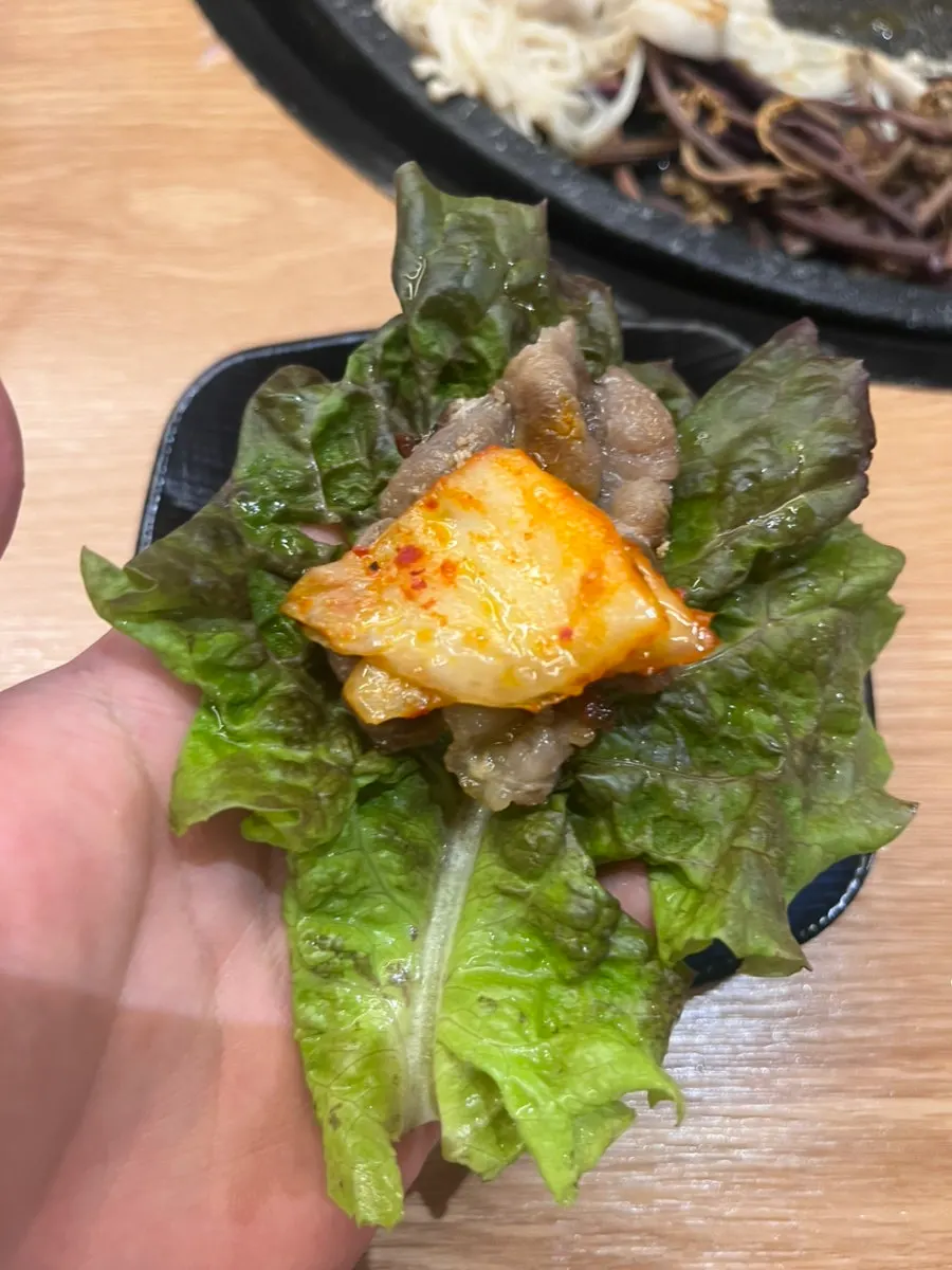 A piece of thin-sliced pork shoulder on a wrap vegetable