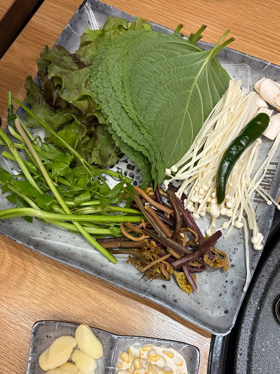 Wrap vegetables from the self-serve bar including lettuce, perilla leaves, and crown daisy