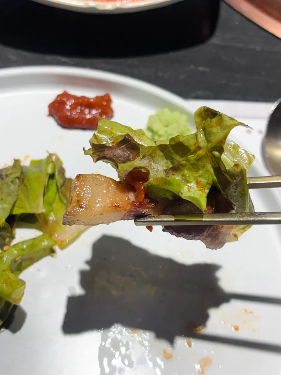A piece of black pork with wasabi and salt