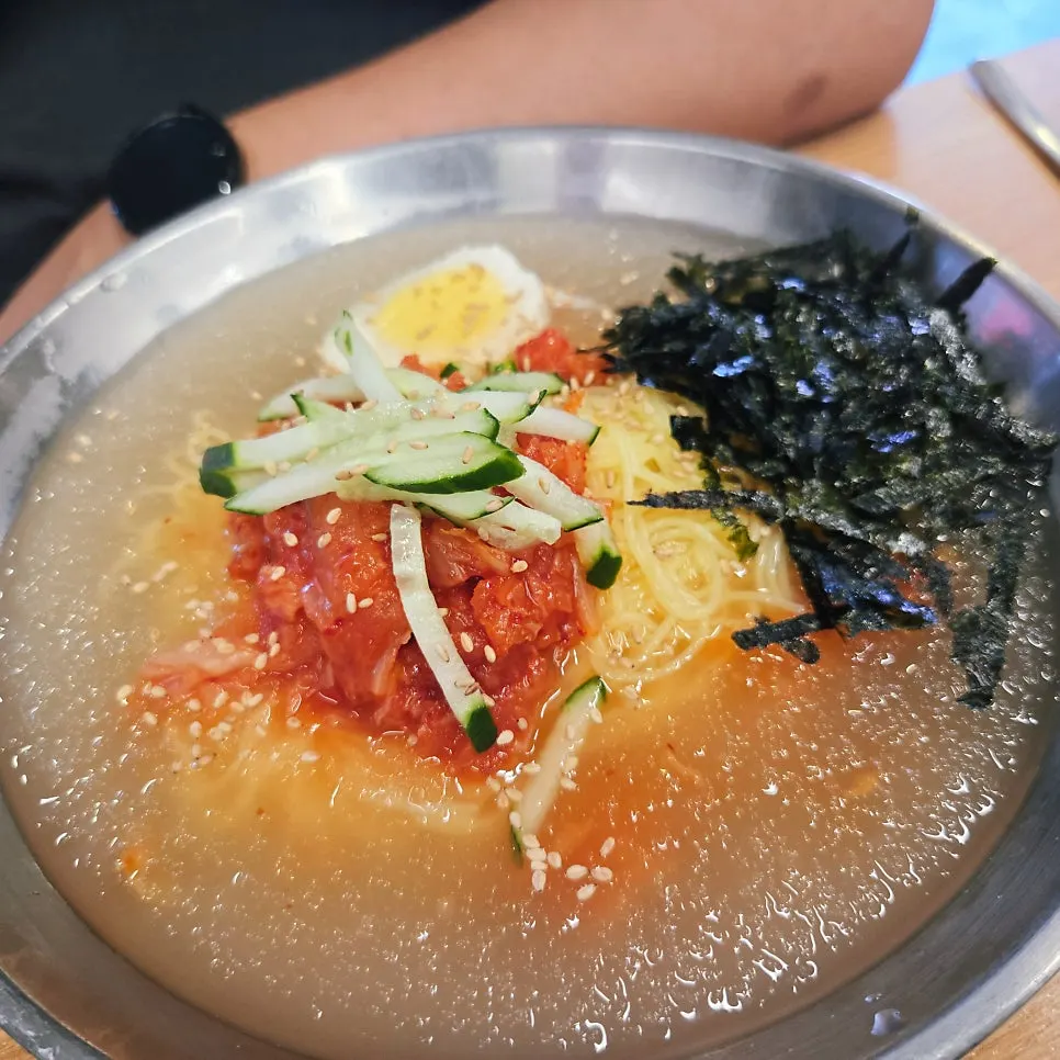 A bowl of cold kimchi noodle soup