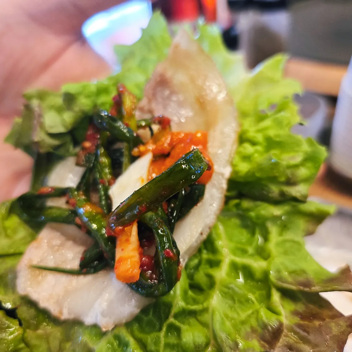 Thin-sliced pork belly topped with green onion kimchi
