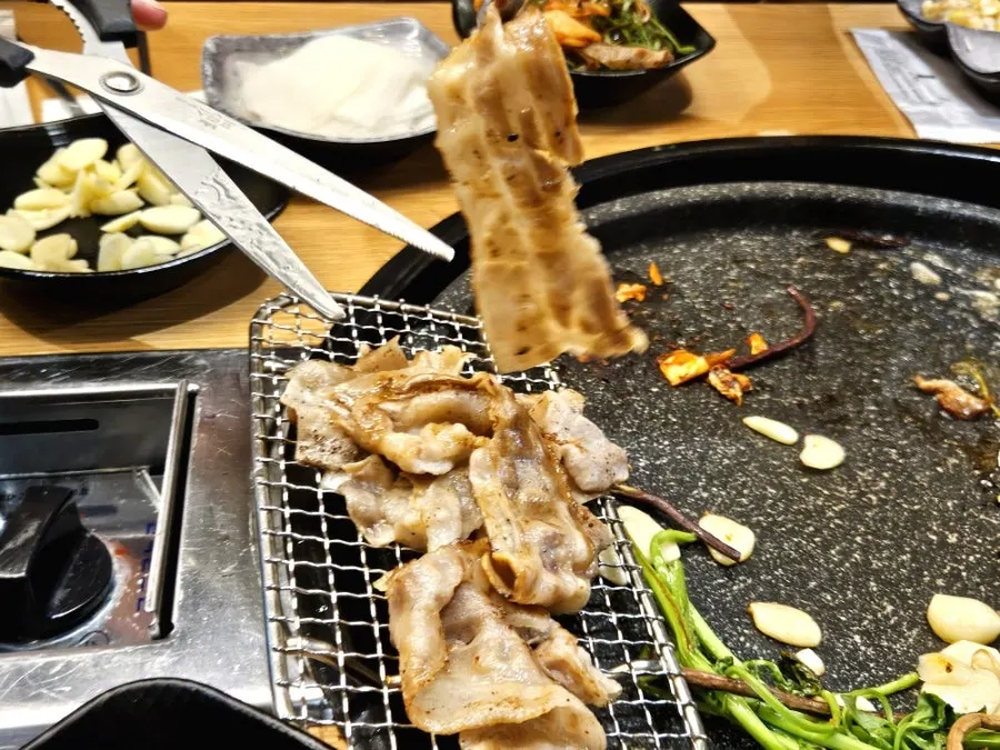 Kimchi and bean sprouts grilling alongside the meat
