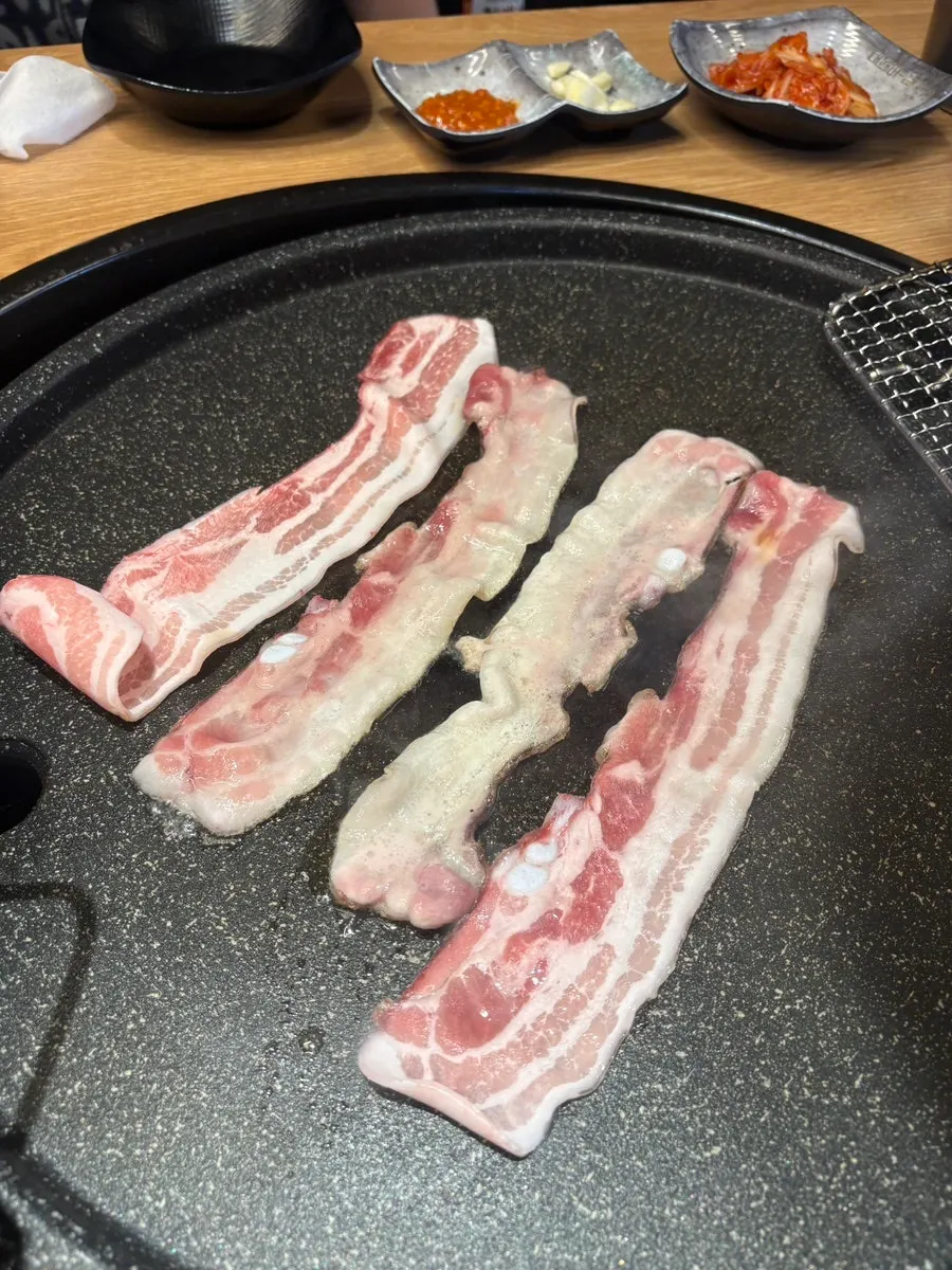 Thin-sliced pork belly on a stone griddle