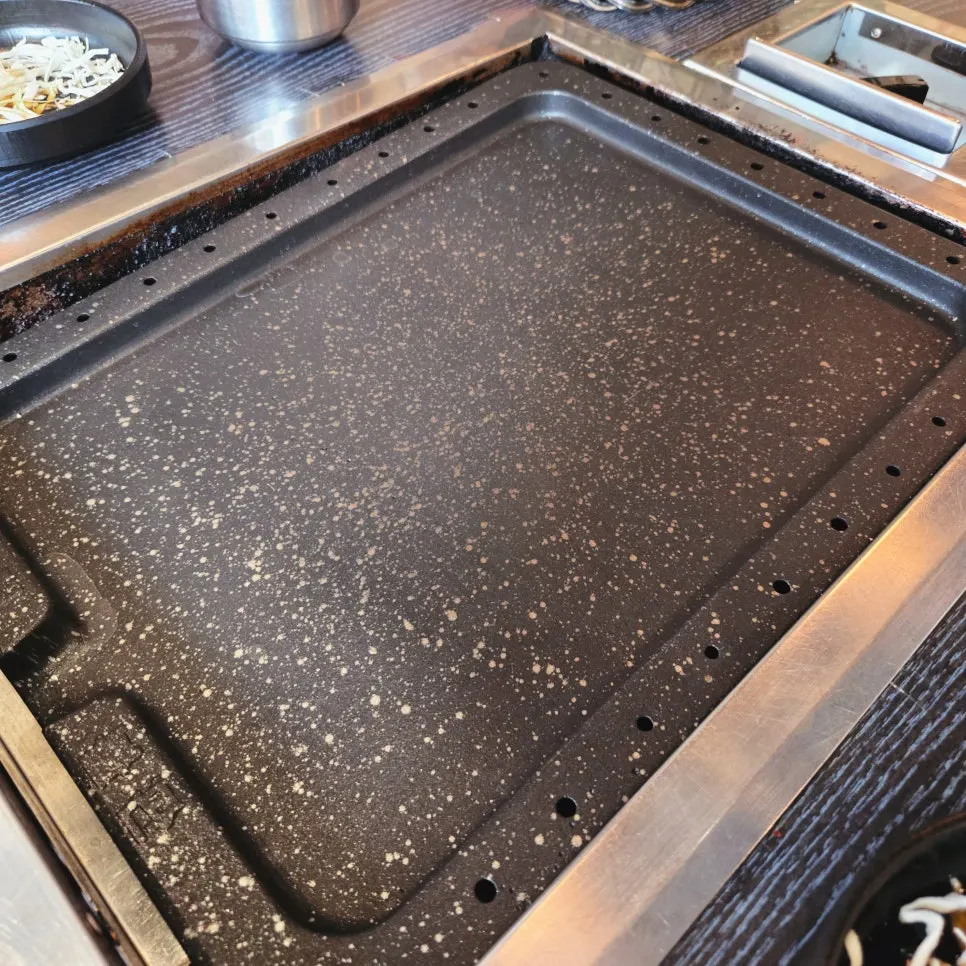 Meat cooking on the heated stone griddle