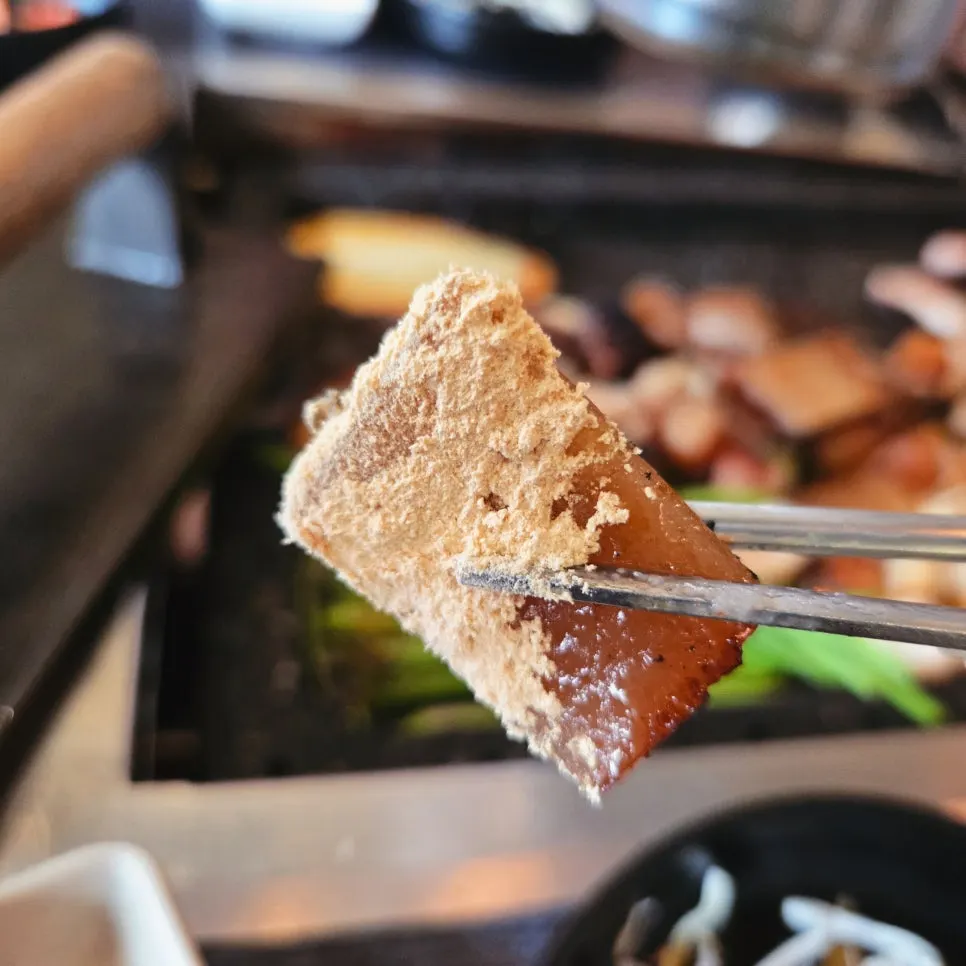 Pork skin being grilled and flattened with the pressing tool