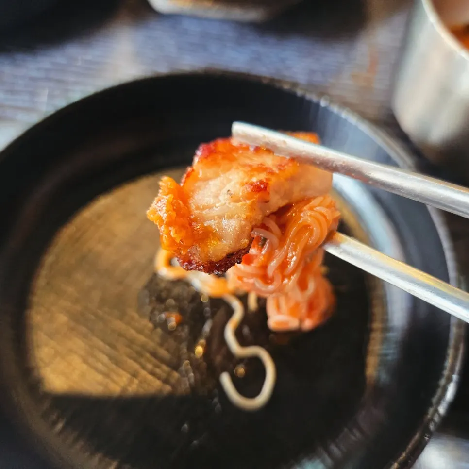 A piece of makchang dipped in sauce