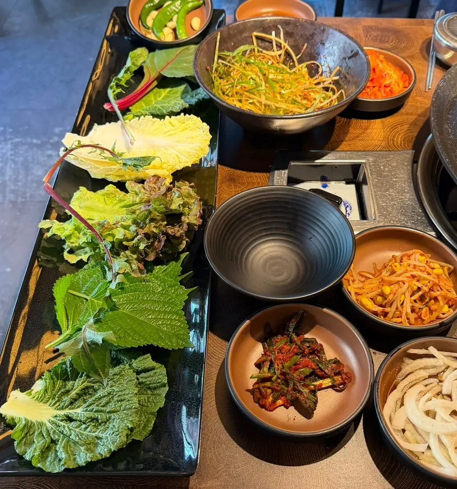 A fresh assortment of lettuce, perilla leaves, and more wrap vegetables