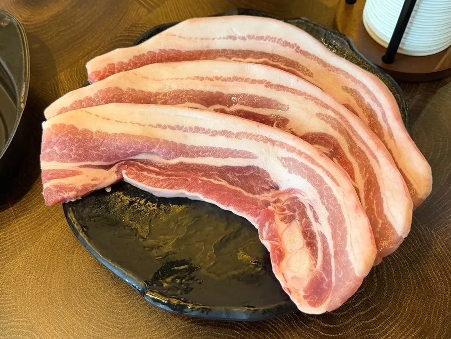 A plate of raw skin-on pork belly
