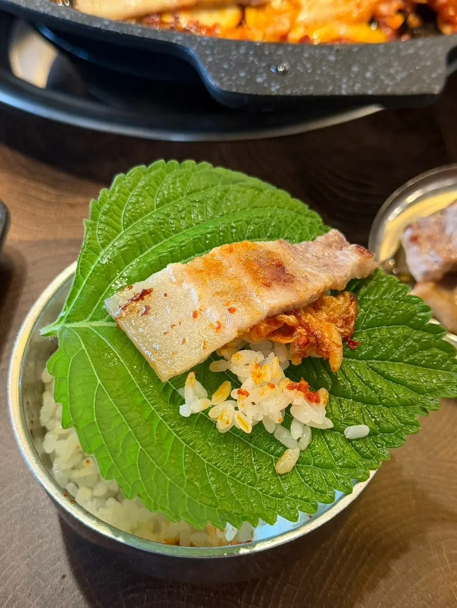 A bite of pork belly eaten with rice