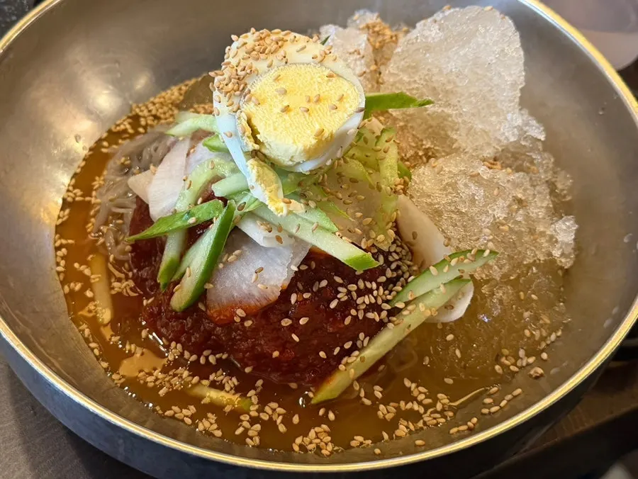 Doenjang stew served alongside meat and rice