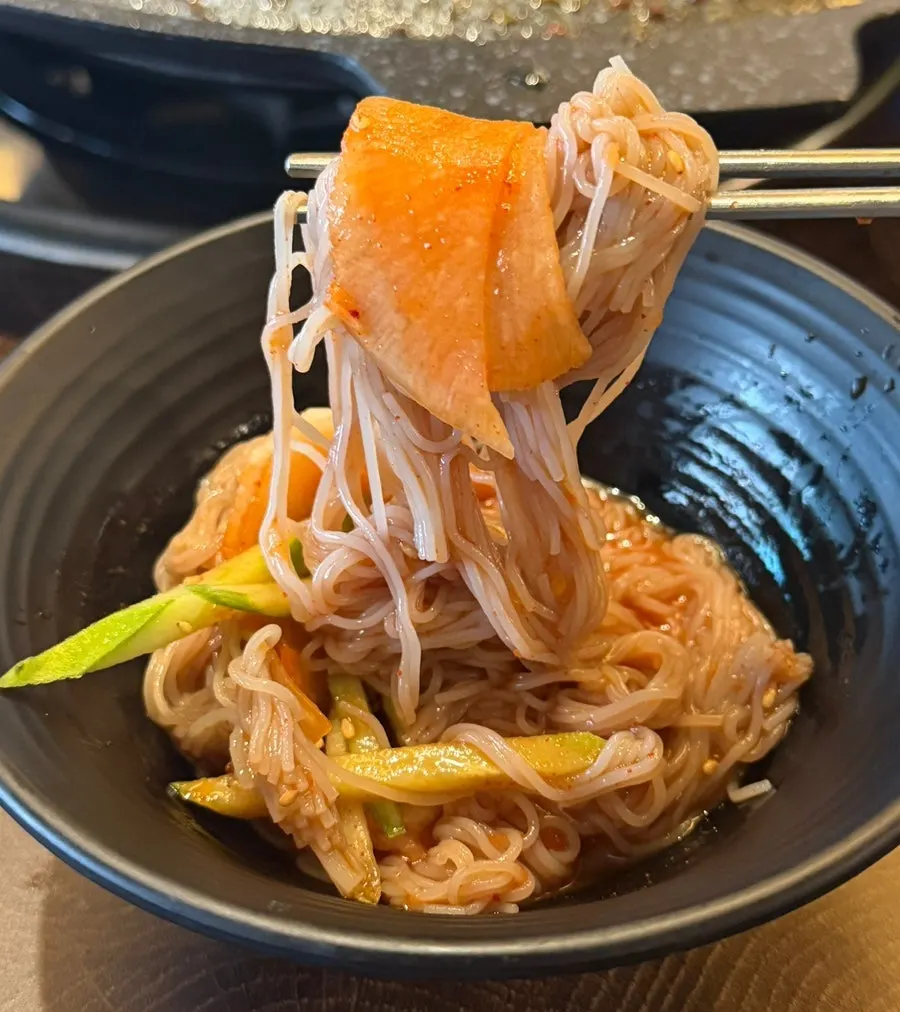 Cold noodle strands evenly coated in seasoning