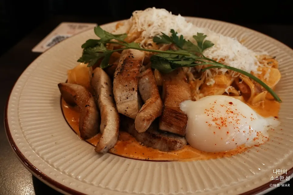 Pork jowl toomba pasta topped with cheese and soft-boiled egg
