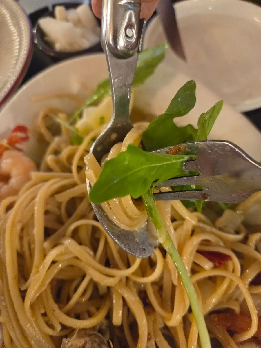 Plate of oil pasta mid-meal