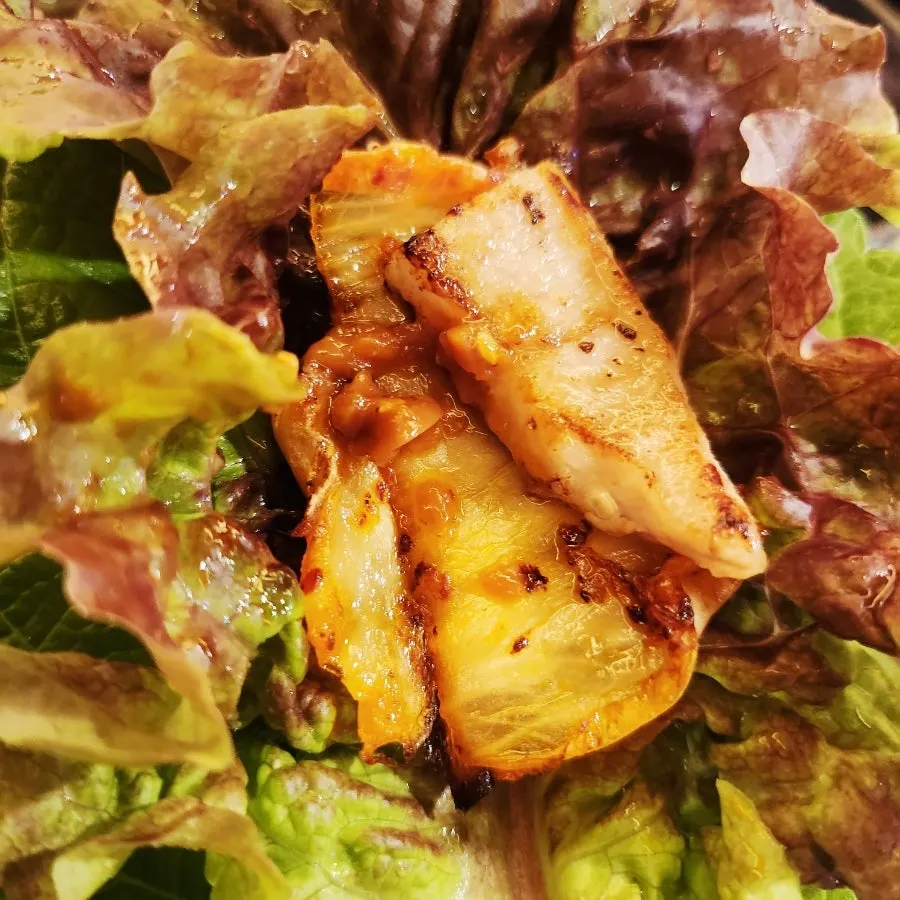 Pork jowl grilled on an iron lid