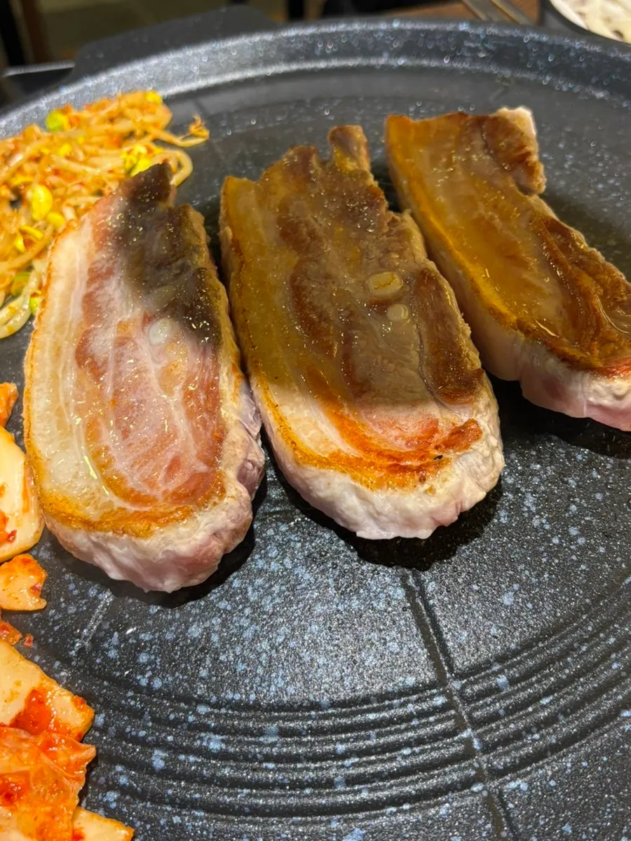 Bean sprouts and kimchi cooking on the edge of the grill