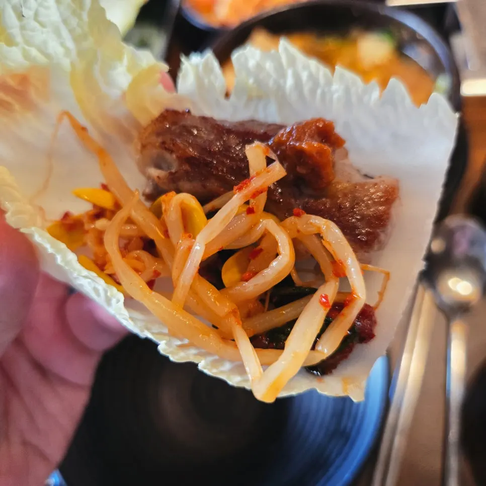 쌈채소에 올린 삼겹살 한 점