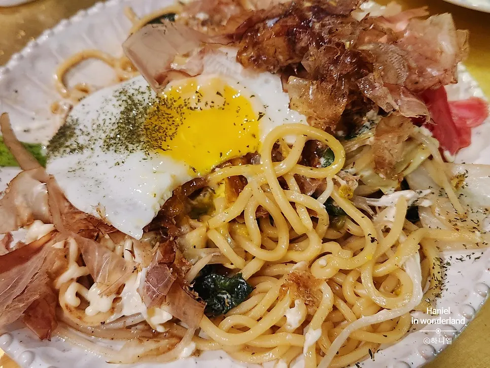 Chopsticks lifting yakisoba noodles with fish cake mixed in