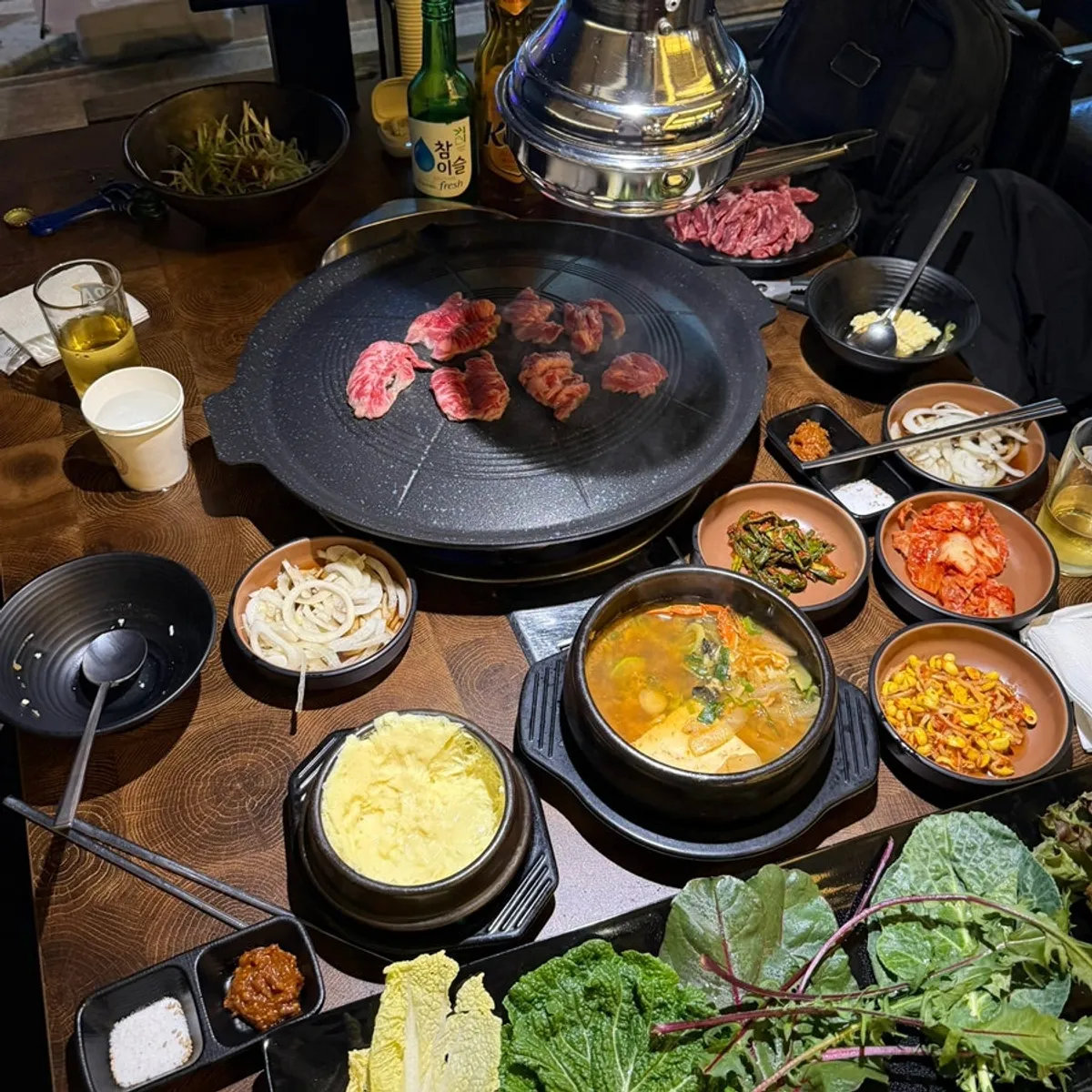 Square photo of galbisal grilling on the cauldron lid