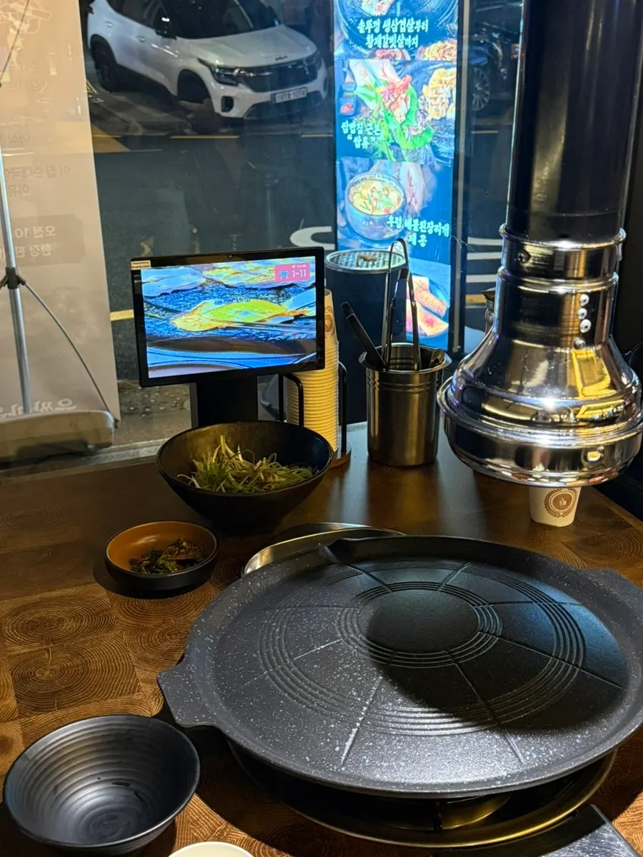 A large cauldron-lid grill set into the middle of the table