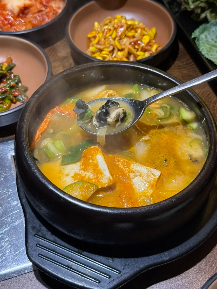 An abalone snail lifted out of the broth