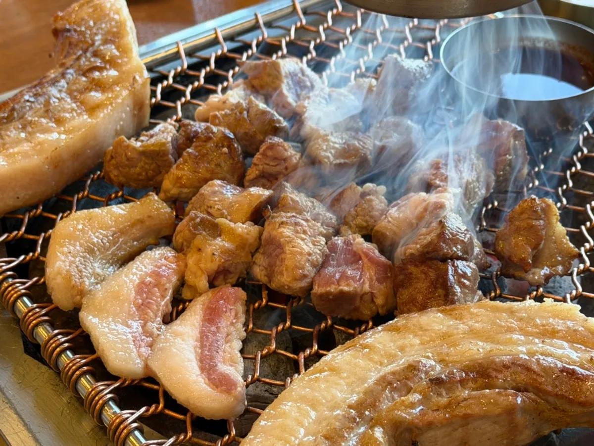 Black pork cooking on a hot grill