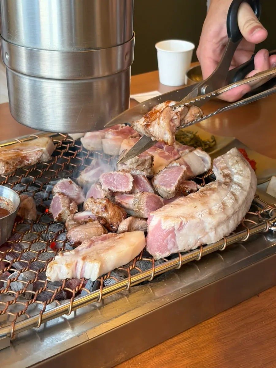 Black pork lined up neatly in rows on the grill