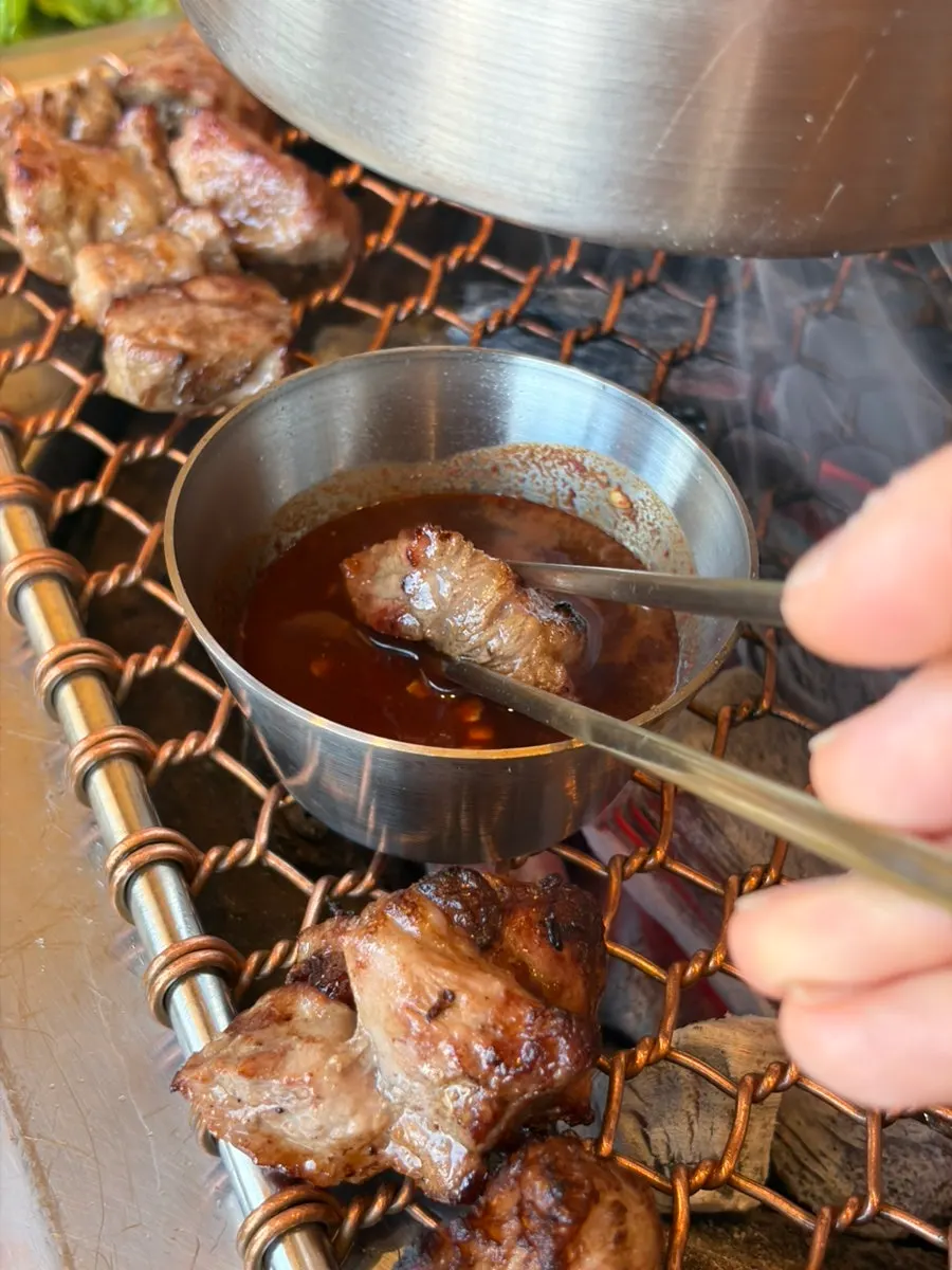 A piece of black pork dipped in fermented anchovy sauce