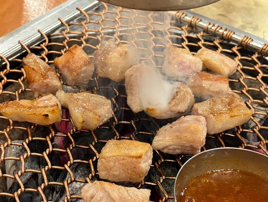 Grilled black pork being dipped in melt jeot