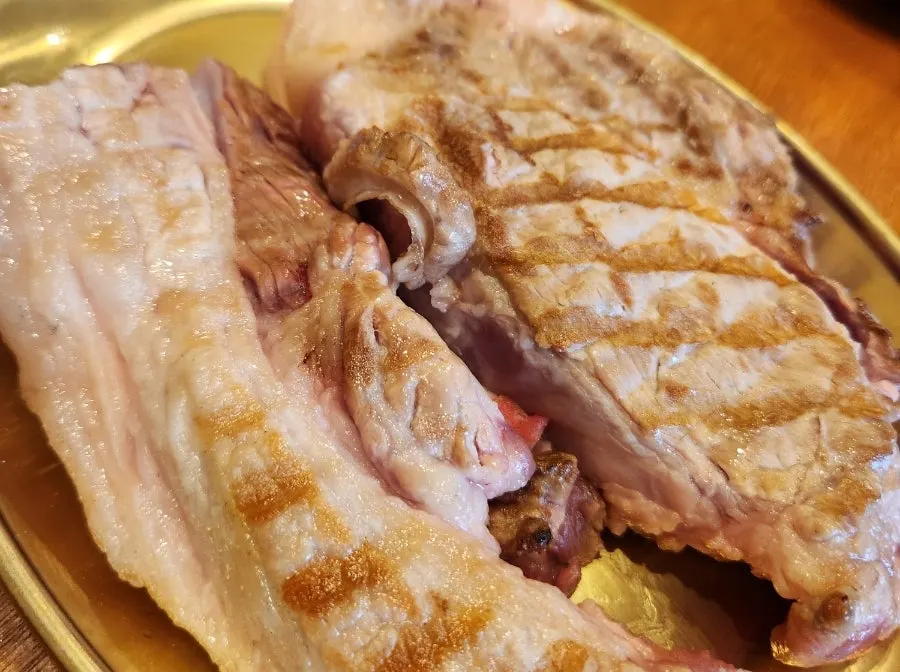 Staff grilling black pork over charcoal as part of the grilling service