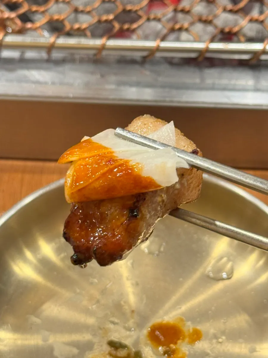 A piece of black pork topped with mu-saengchae